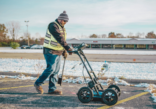 Utility worker marking underground utility locates with paint