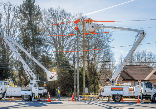 Hickory, NC, USA-14 Feb 2023: Utility workers with two bucket trucks repairing electrical lines.