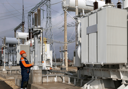 A power engineer inspects substation equipment. Energy. Industry