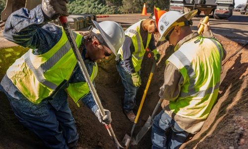 4 construction workers digging 
