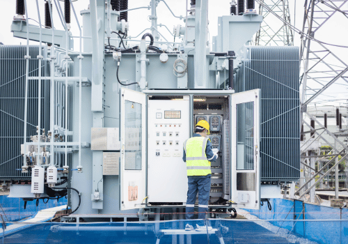 An engineer is working on high voltage power substation performing inspection and check to ensure infrastructure operates safely and efficiently in this industrial environment