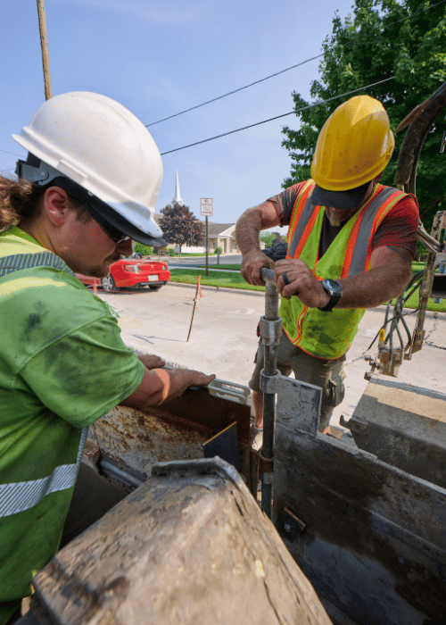 Photo of two construction workers working together on a jobsite