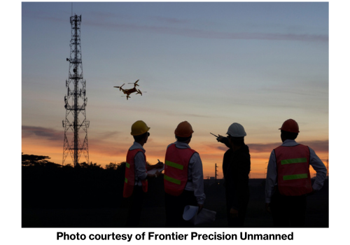 Frontier Precision Unmanned utility workers flying drone near powerline