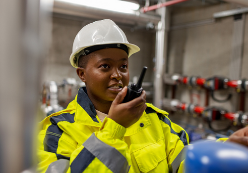 Female worker using walkie talkie to communicate.