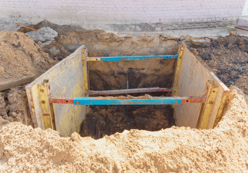 Trench to repair the pipe break. Walls reinforced with metal supports to prevent sloughing of the soil.