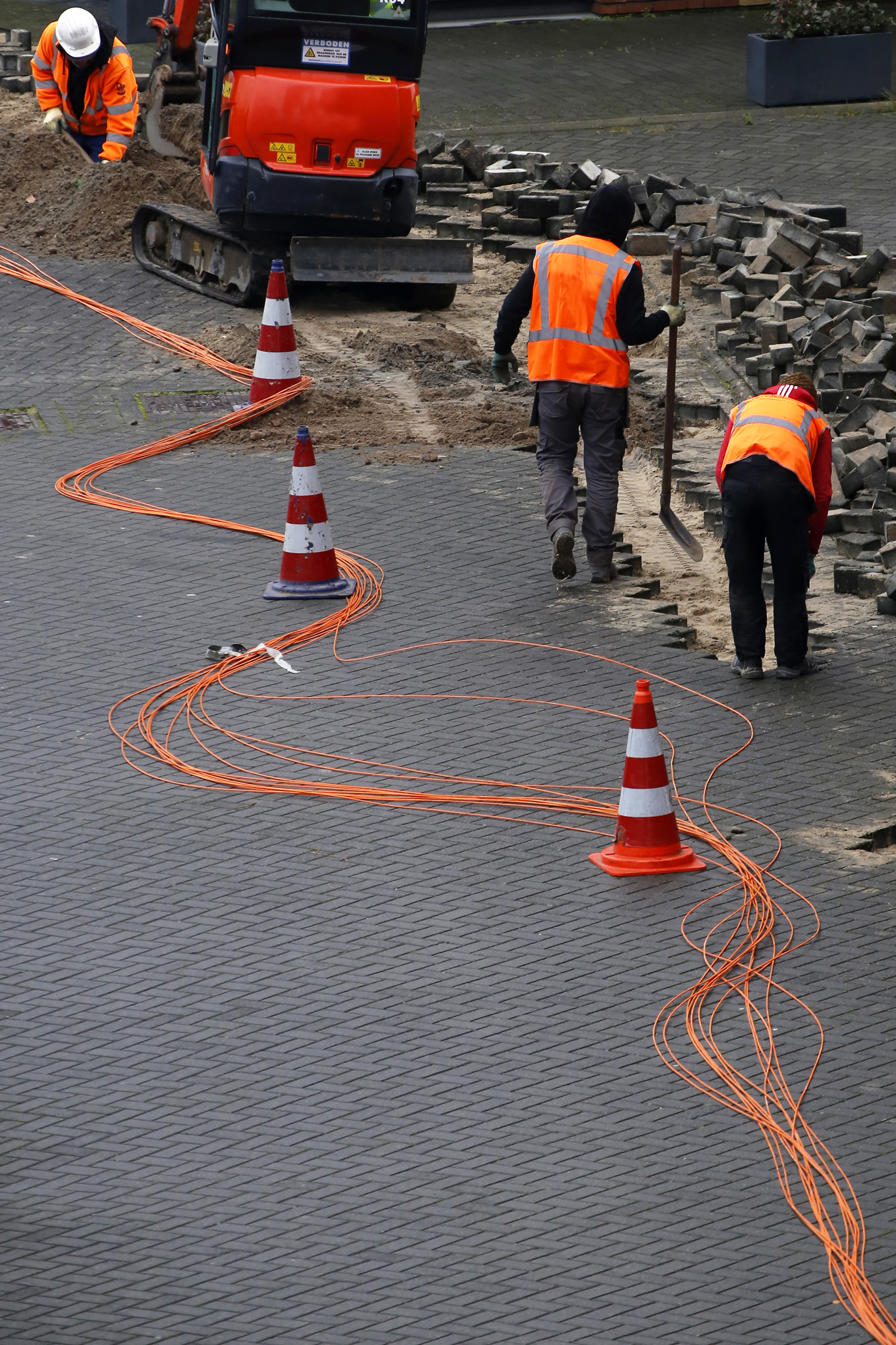 Technical engineers installing fiber optic cables to neighboring houses, 