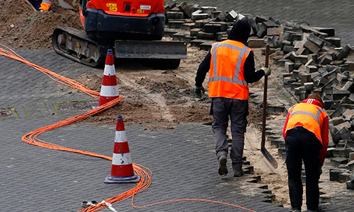 Technical engineers installing fiber optic cables to neighboring houses, 