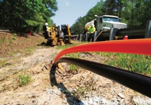 Utility workers installing fiber optic cable underground
