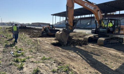 Worksite with excavator in the background