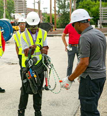 Utility worker training student outside